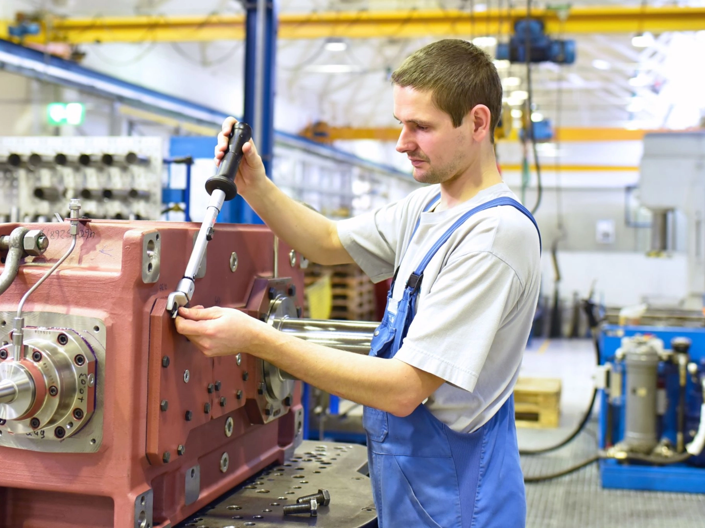 Beschäftigter arbeitet an einem Getriebe in einer Fabrik