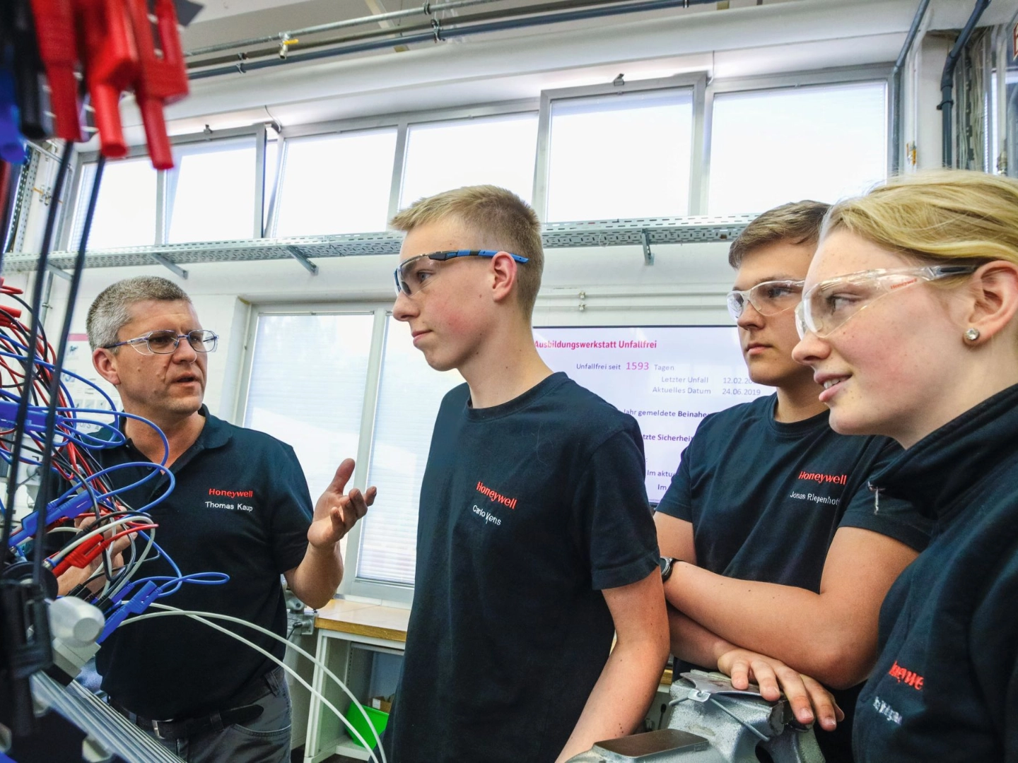 junge Auszubildende lernen eine Roboteranlage zu bedienen