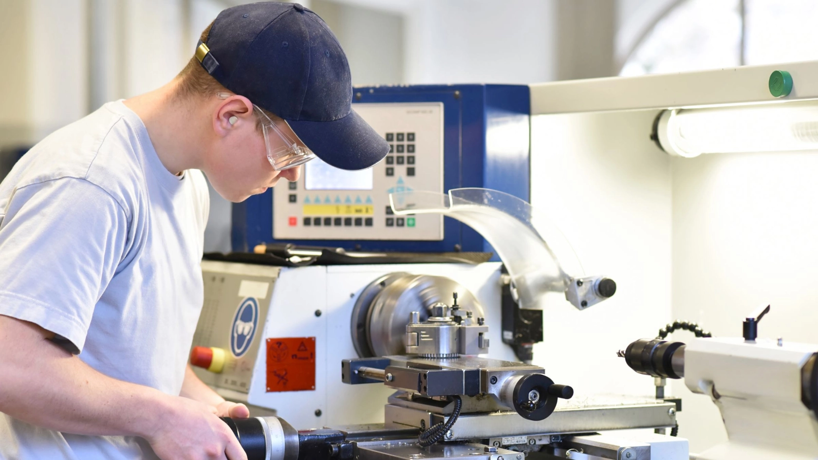 junger Mann arbeitet an einer Drehmaschine