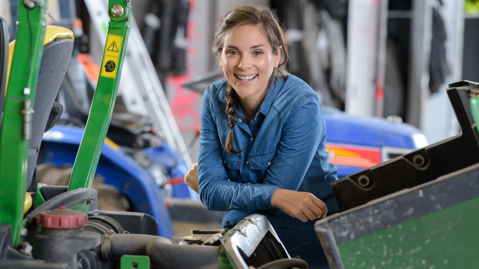 Arbeitnehmerin in einer Werkstatt mit Landmaschinen
