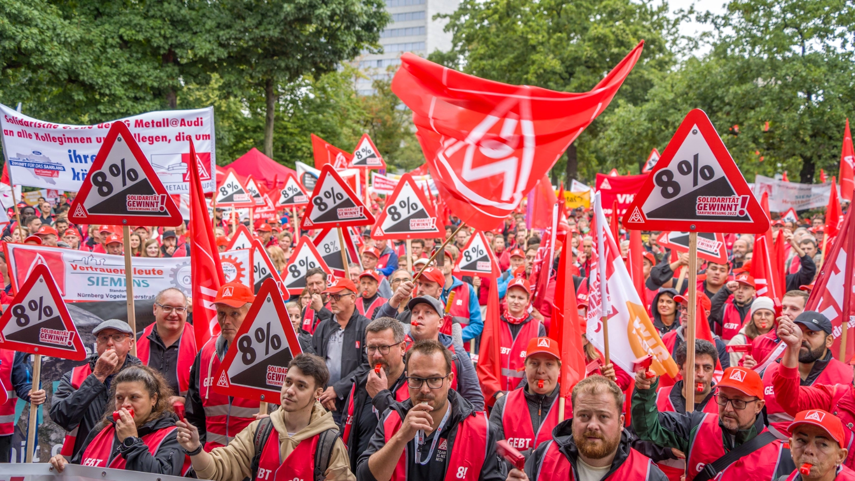 Menschenmenge vor Bühne mit Flagge, Cape & 8% Schilder