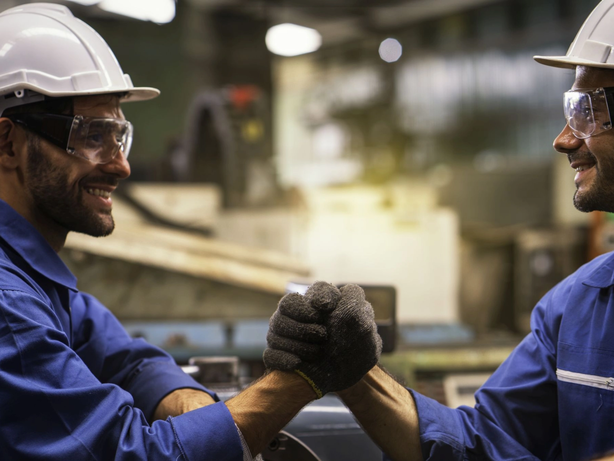 Industriearbeiter geben sich in Fabrik die Hände