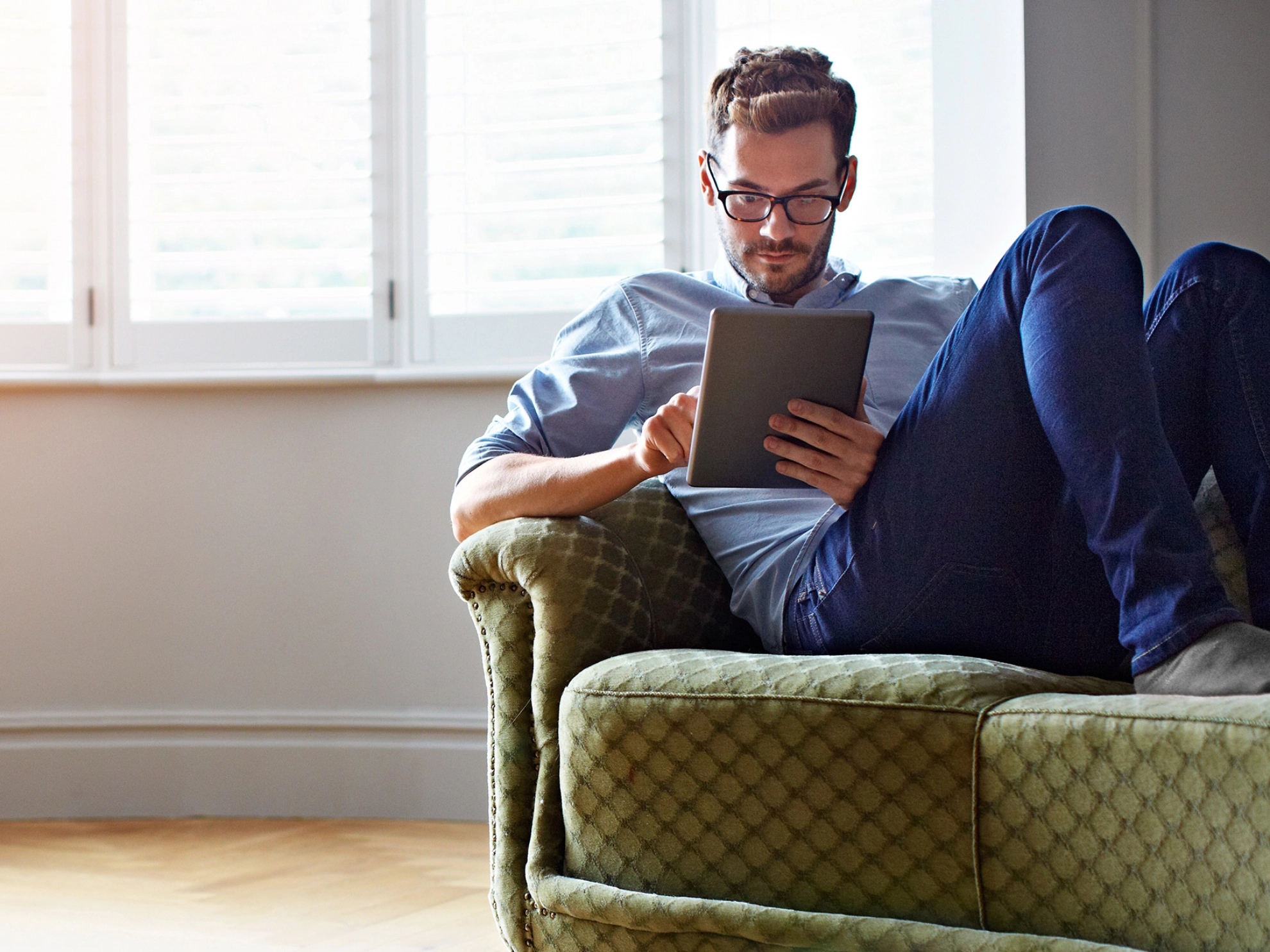 Mann mit Tablet auf dm Sofa