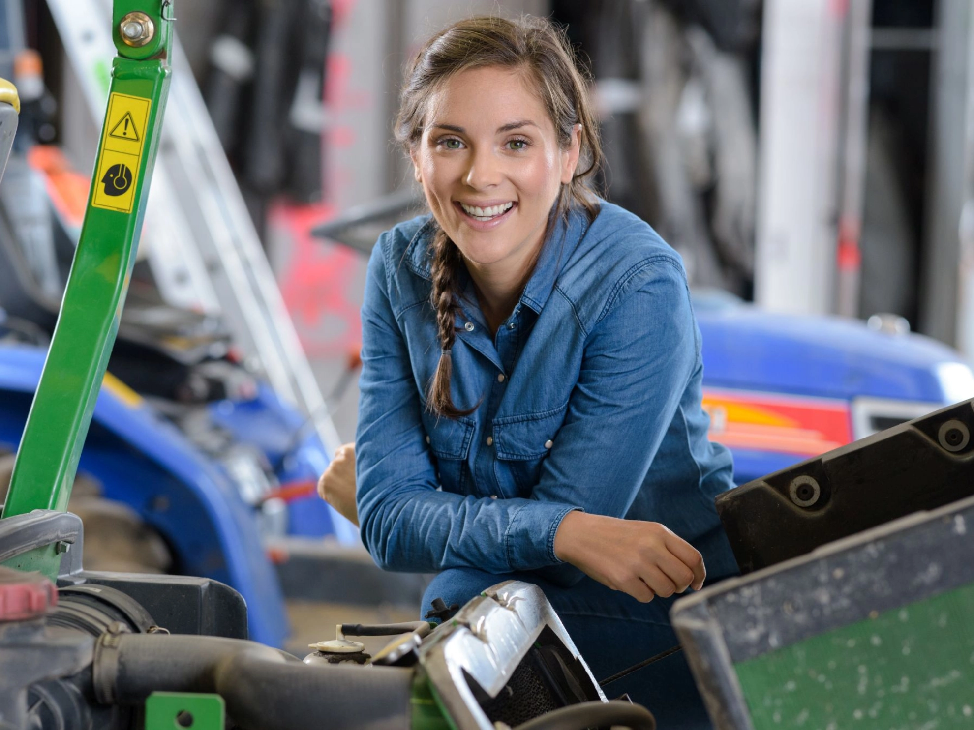 Arbeitnehmerin in einer Werkstatt mit Landmaschinen