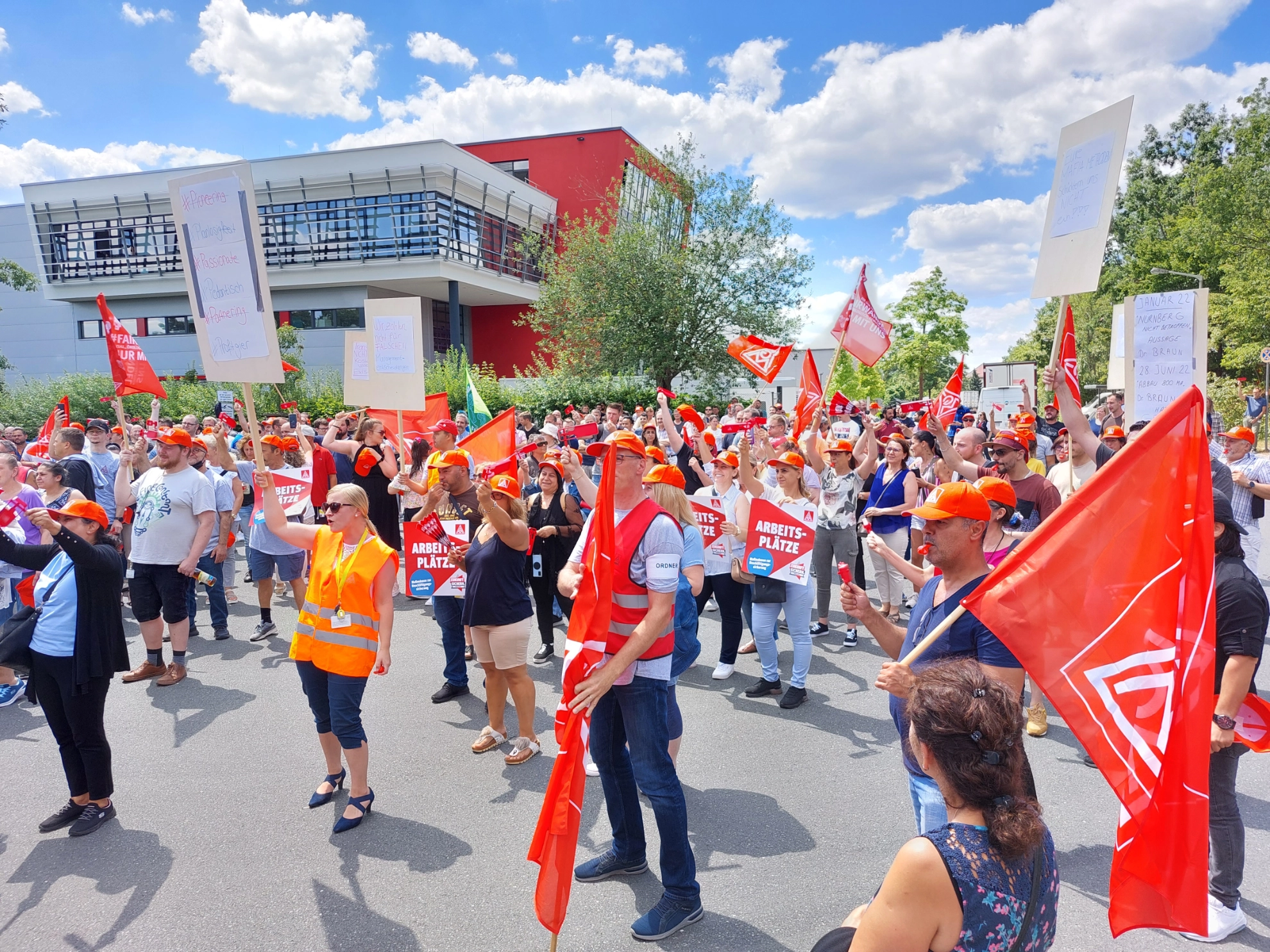 Protestaktion bei Vitesco gegen Stellenabbau; Menschenmenge mit Fahnen, Plakaten und roten Capes