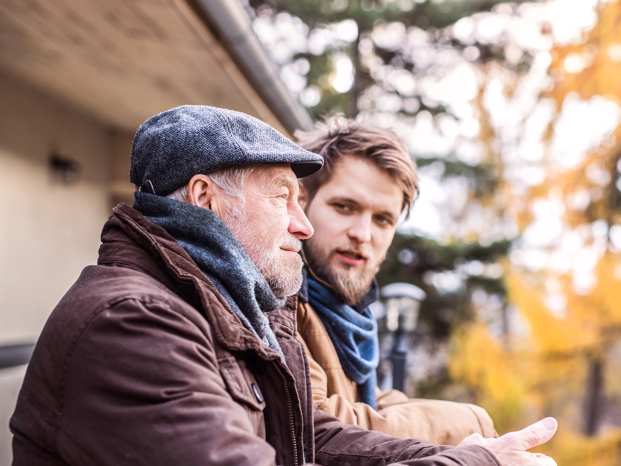 Vater und Sohn genießen zusammen den schönen Herbsttag auf dem Balkon