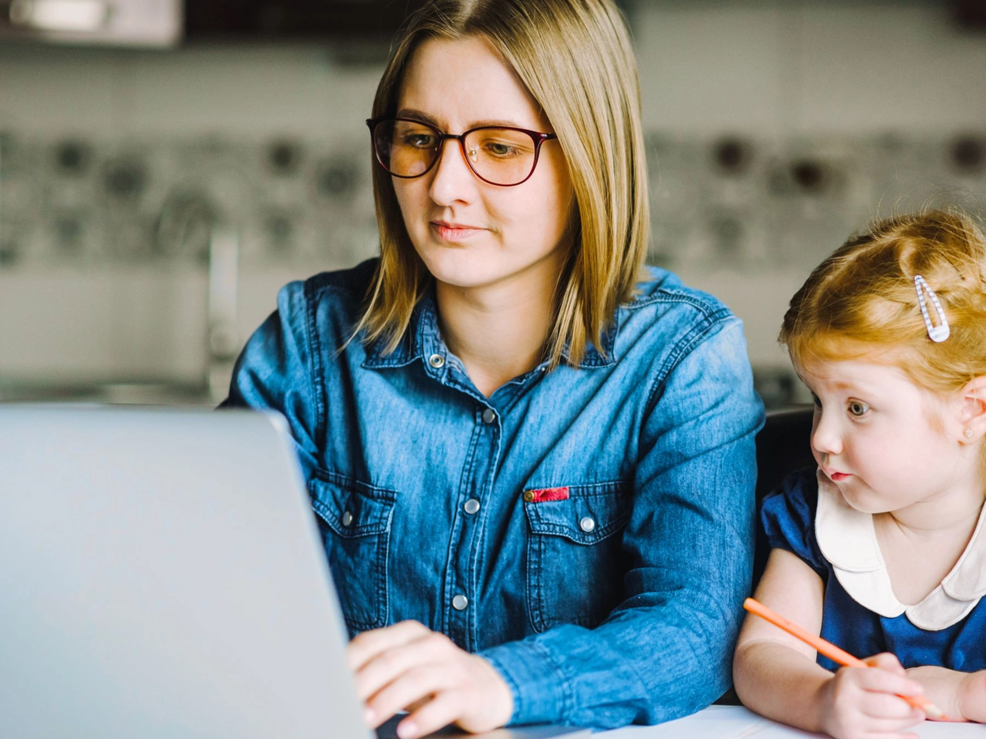 Mutter mit kleiner Tochter gemeinsam an einem Laptop