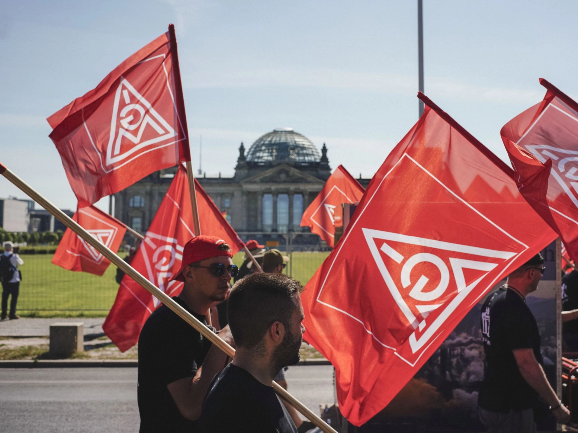 Metaller laufen mit IG Metall-Fahnen am Bundestag in Berlin vorbei zur FairWandel-Kundgebung